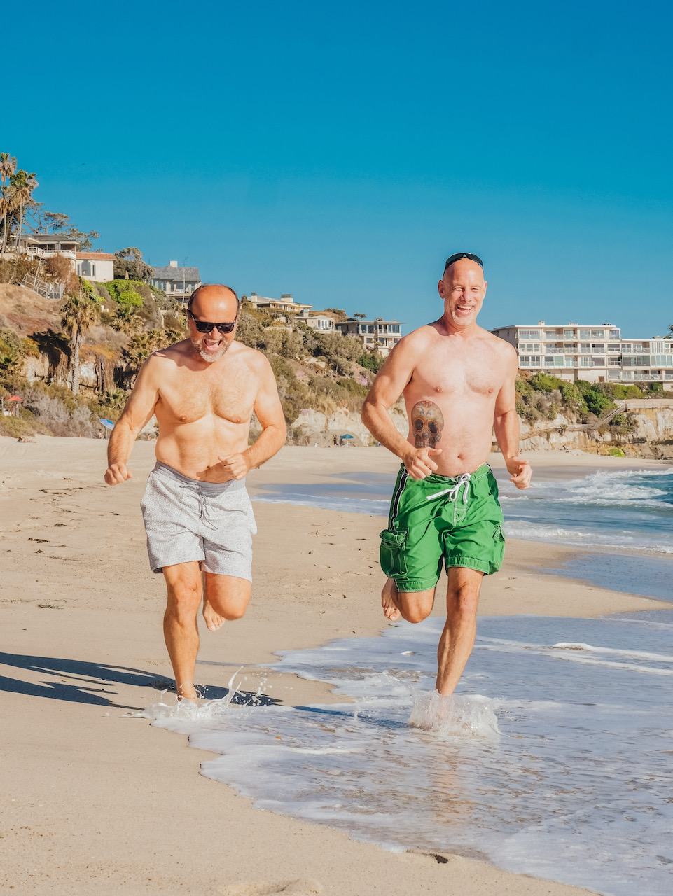 Two young men running down the beach