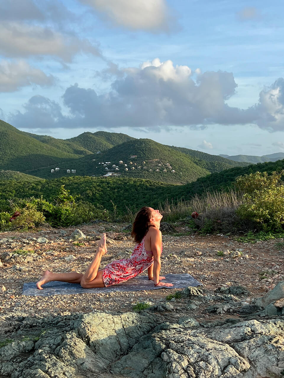 A woman performing yoga near the mountains